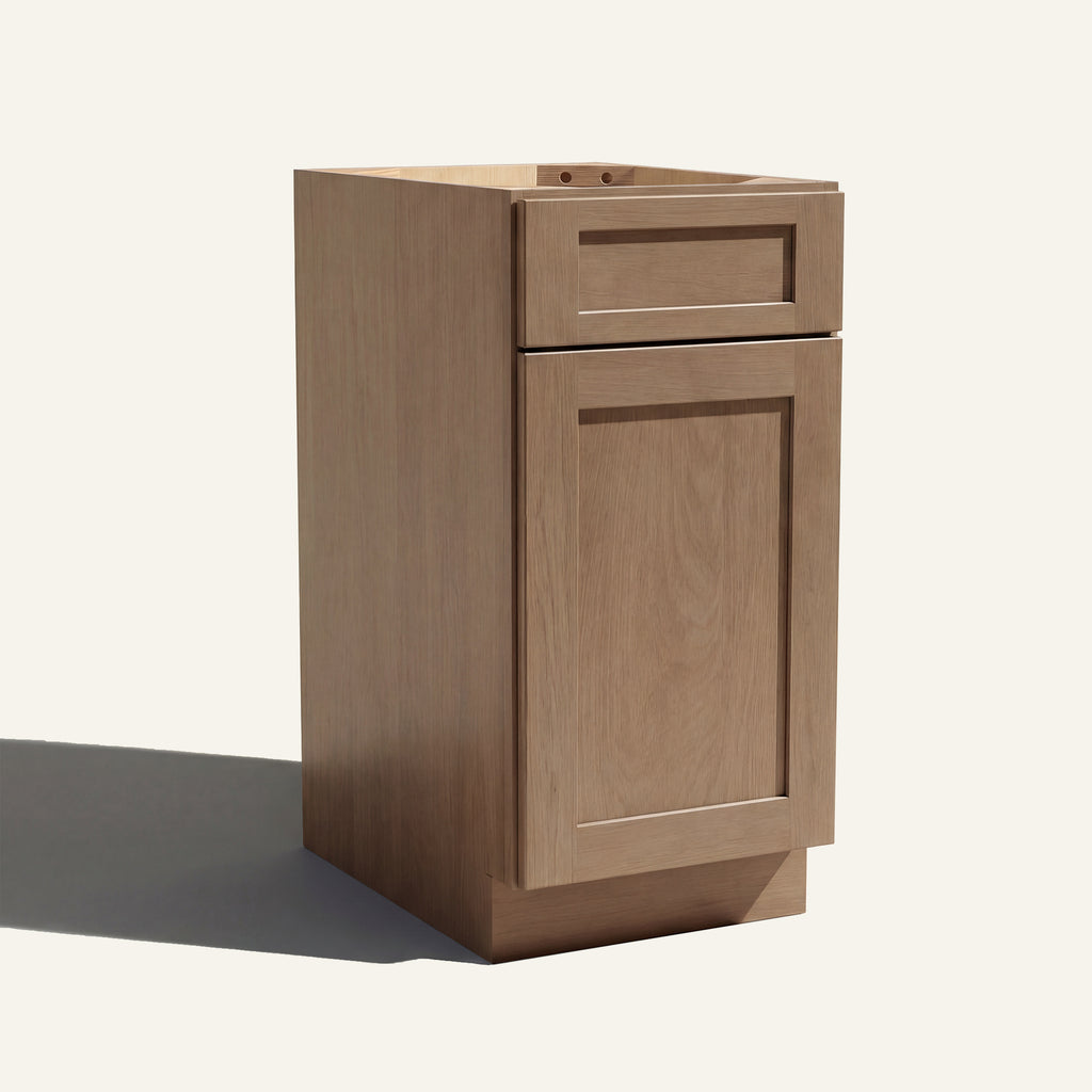 Angled view of a driftwood Seaport Shaker vanity base cabinet with 1 door and 1 drawer.