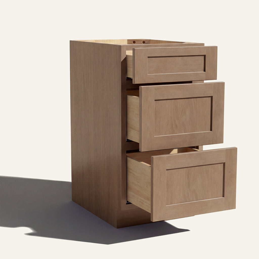 Angled view of a driftwood Seaport Shaker 3-drawer vanity base cabinet with drawers open showing solid wood drawer boxes.