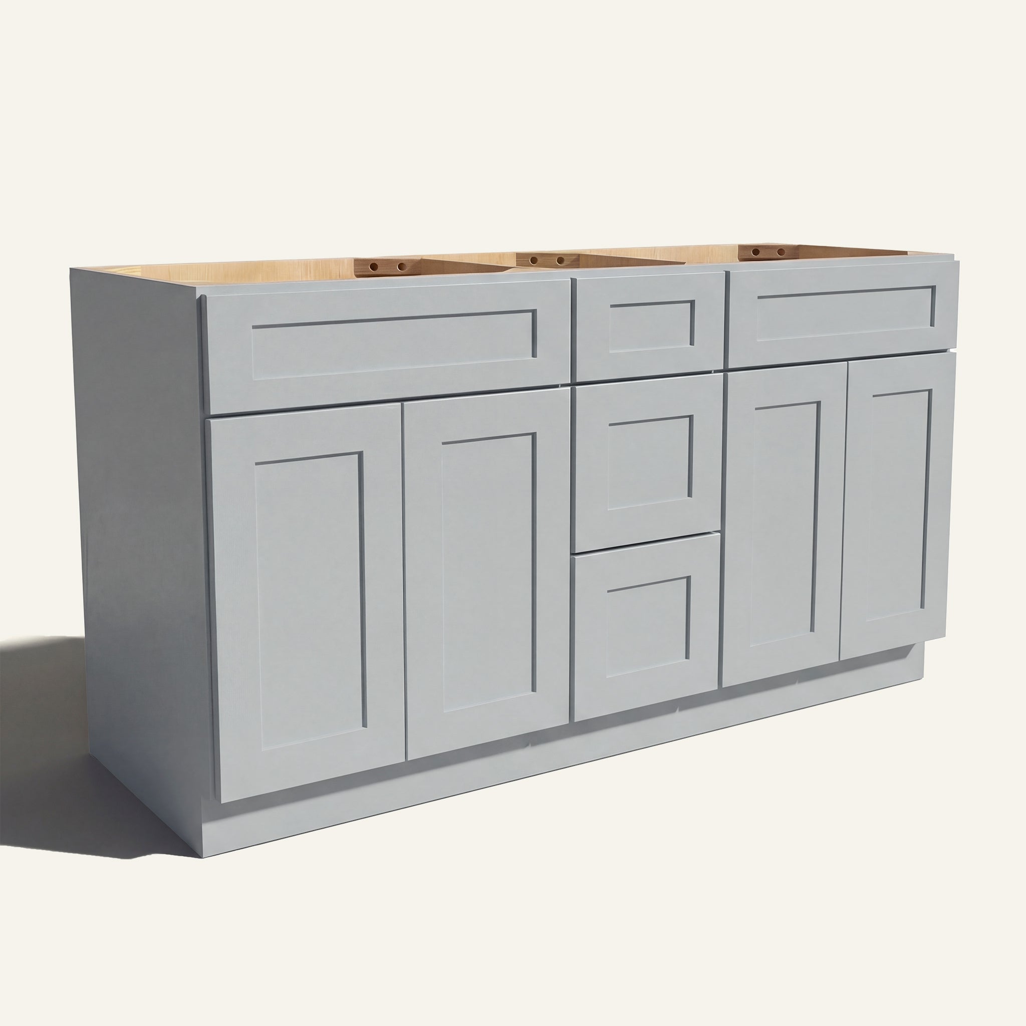 Angled view of a light gray Seaport Shaker double sink vanity base with 4 doors, 3 drawers, and 2 false drawer fronts.