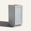 Angled view of a light gray Seaport Shaker base cabinet with 1 full-height door.