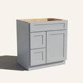 Angled view of a light gray Seaport shaker single sink vanity with a right-side door and two left-side drawers.