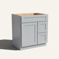 Angled view of a light gray Seaport shaker single sink vanity with a left-side door and two right-side drawers.
