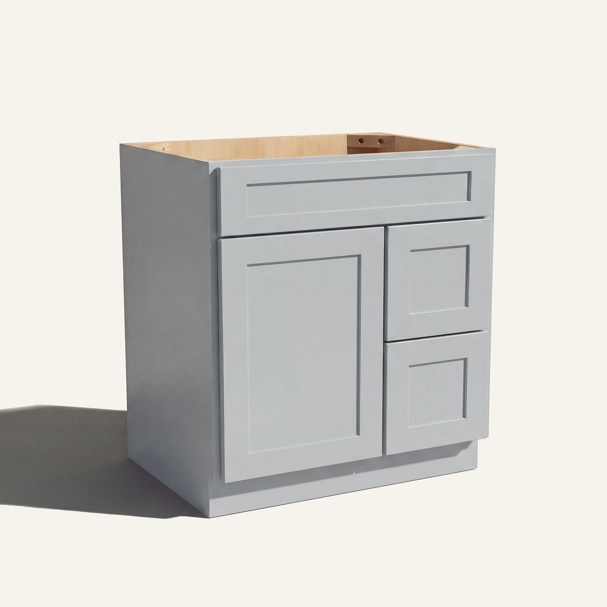 Angled view of a light gray Seaport shaker single sink vanity with a left-side door and two right-side drawers.