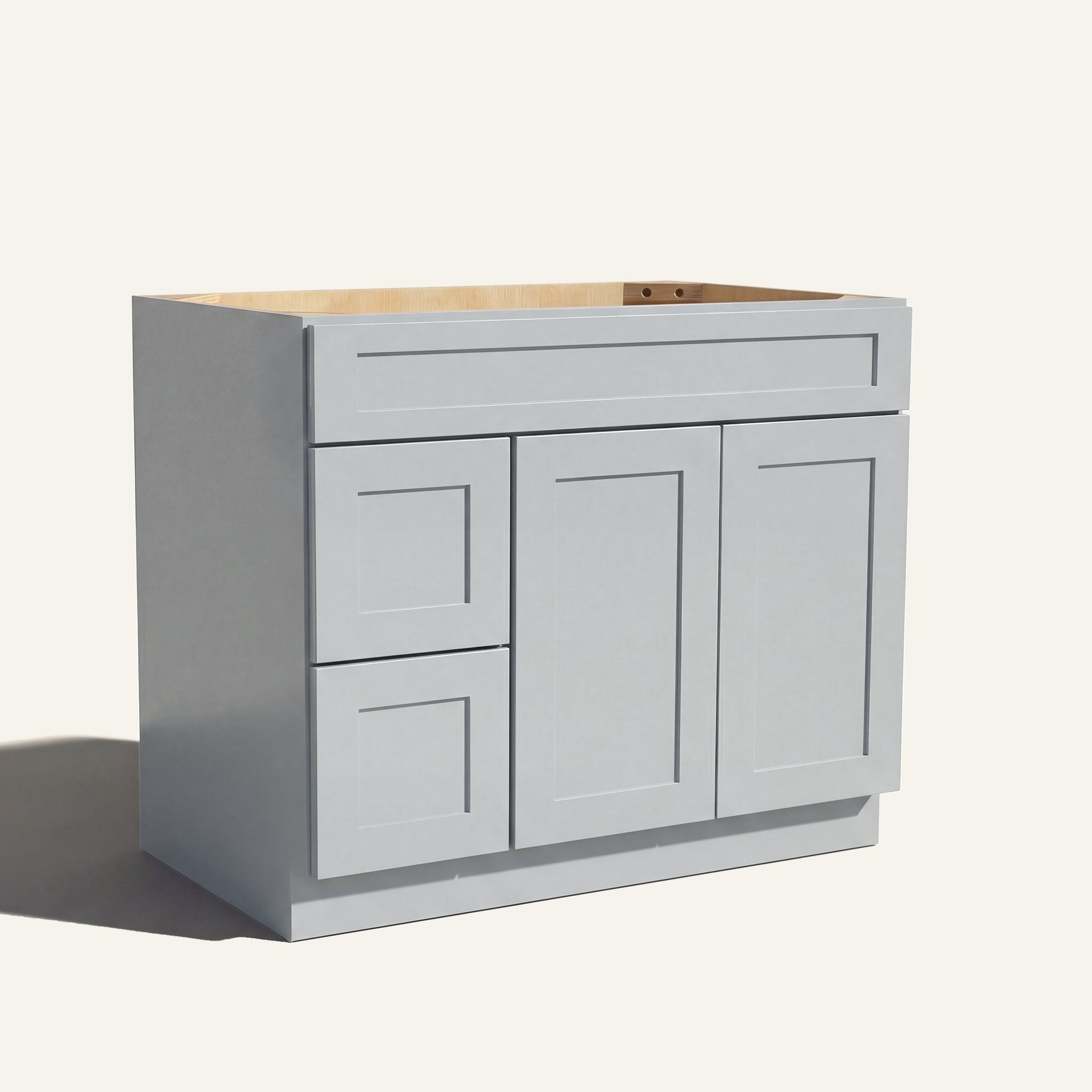 Angled view of a light gray Seaport shaker single sink vanity featuring two doors and a left-side drawer bank.