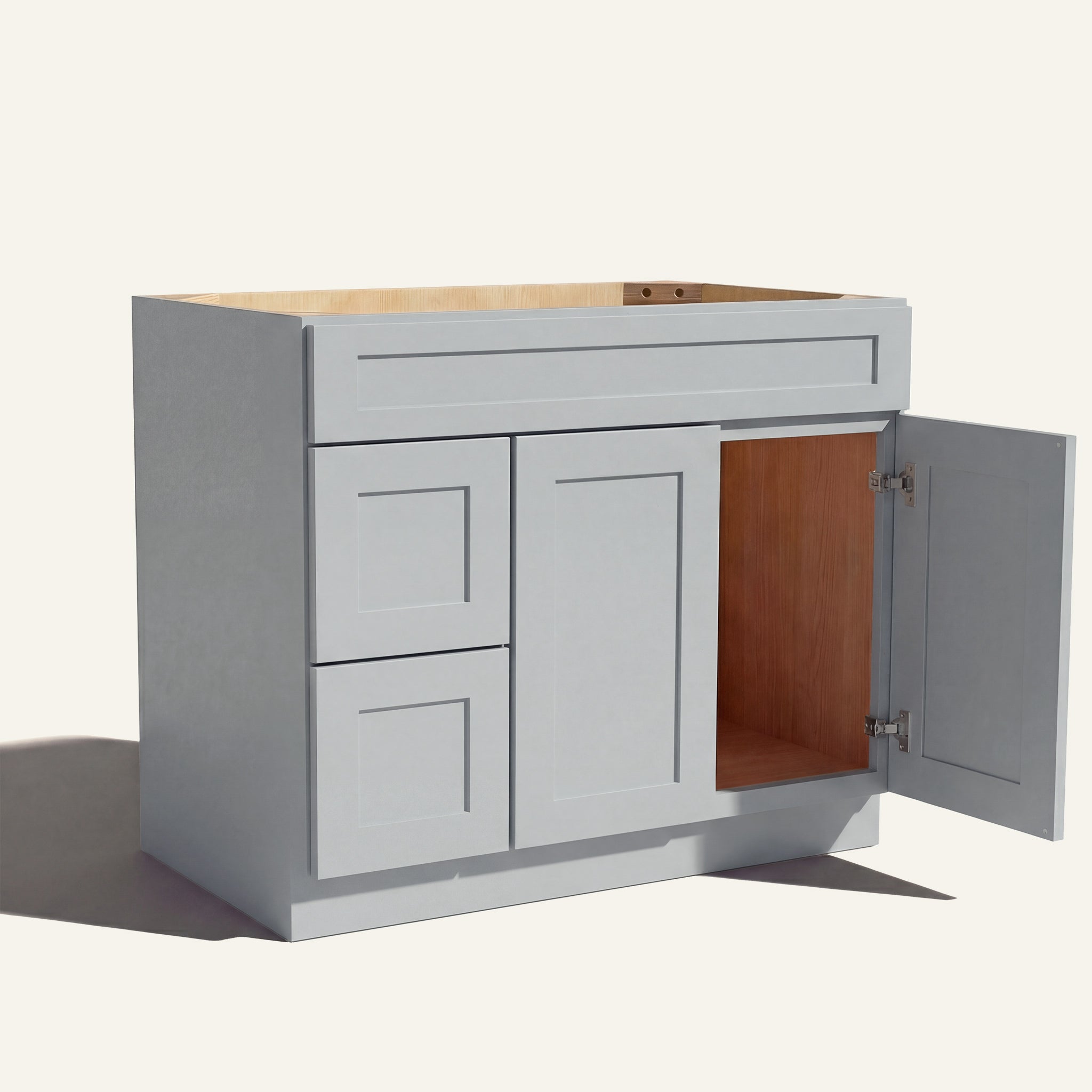 Open right door view of a light gray Seaport shaker single sink vanity featuring two doors and 2 left-side stacked drawers.