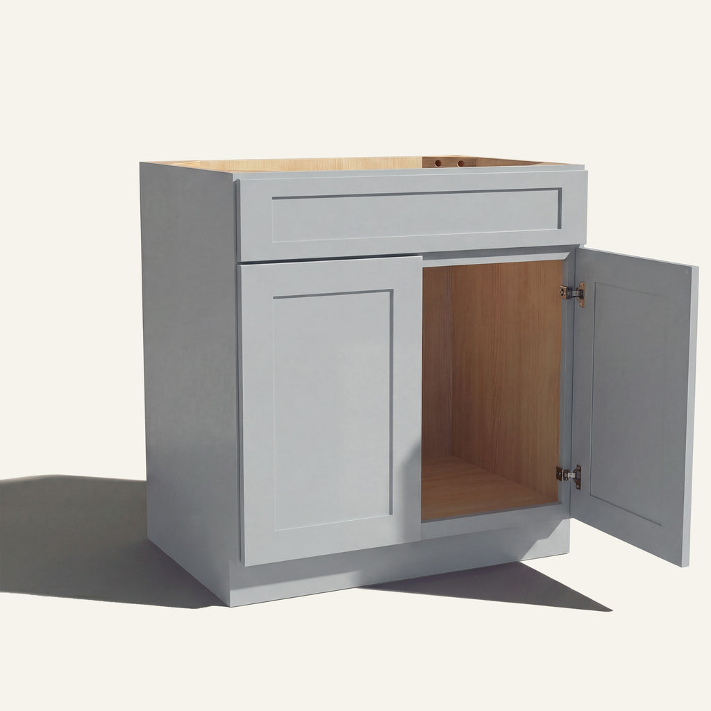 Angled view of light gray Seaport Shaker single sink vanity, 1 false front, 2 doors with right one open to a wood interior.