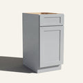 Angled view of a light gray Seaport Shaker vanity base cabinet with 1 door and 1 drawer.