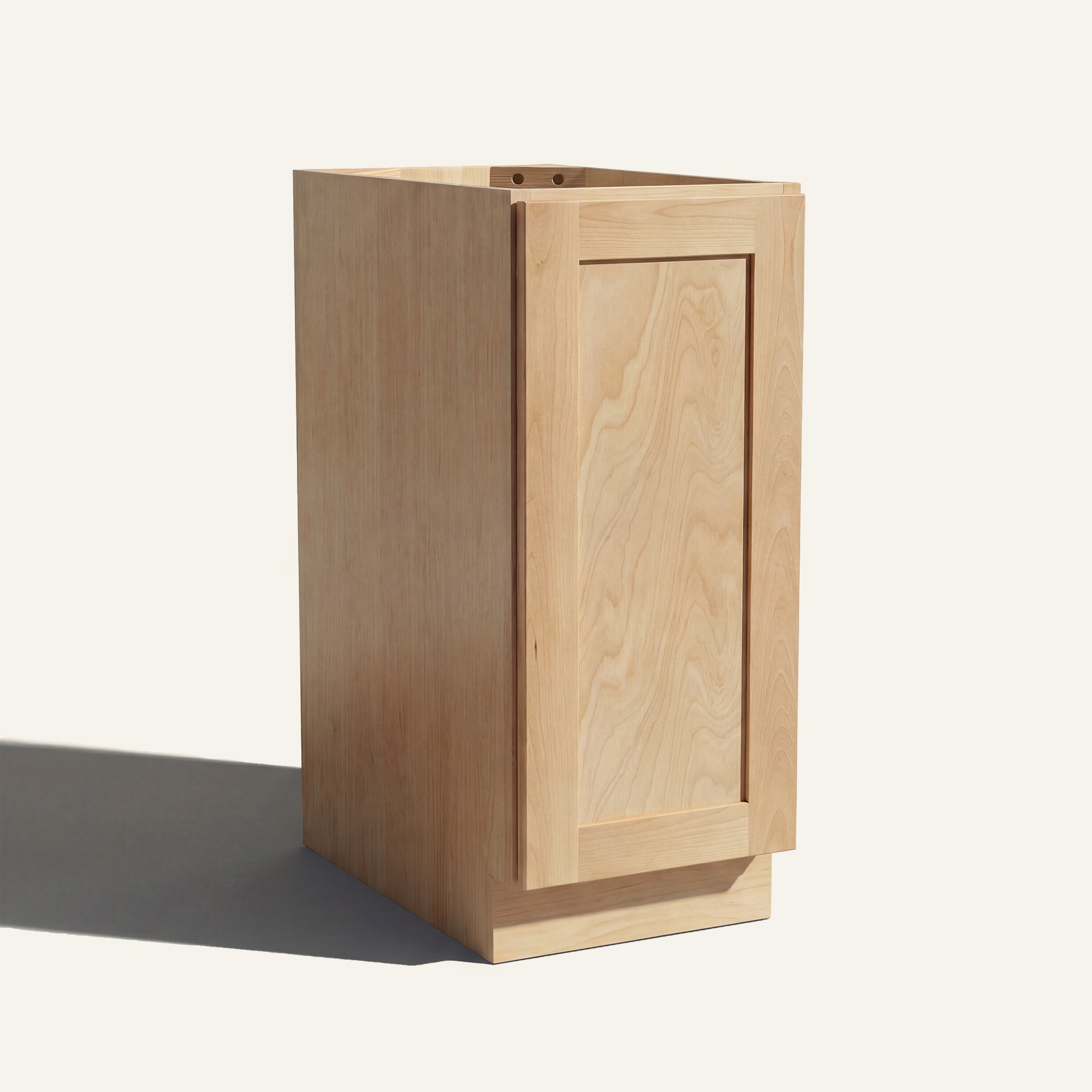 Angled view of a natural Seaport Shaker base cabinet with 1 full-height door.