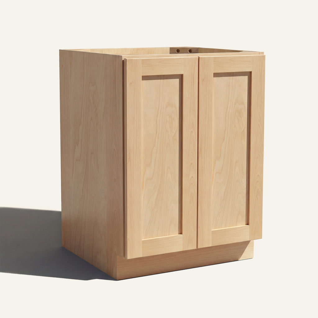 Angled view of a natural Seaport Shaker base cabinet with 2 full height doors.