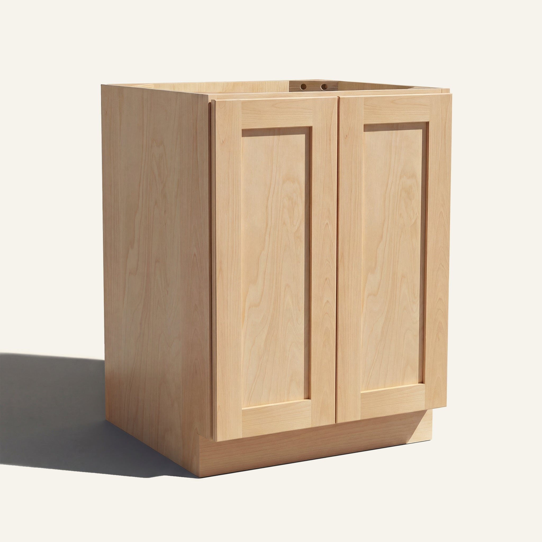Angled view of a natural Seaport Shaker base cabinet with 2 full height doors.