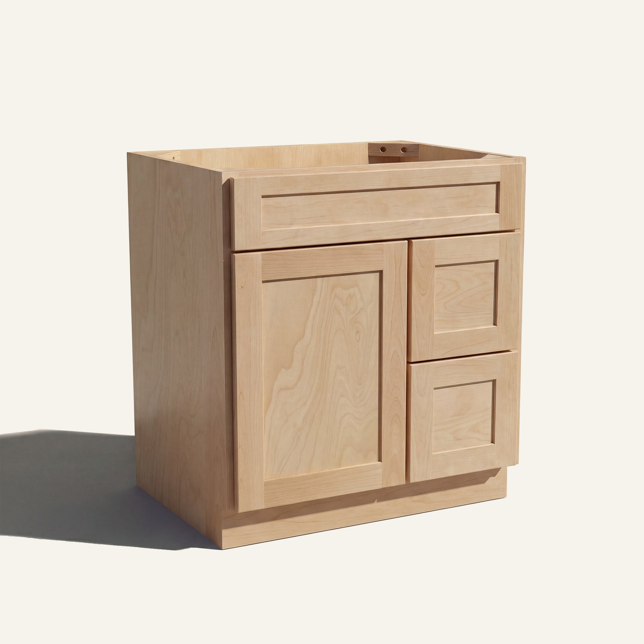 Angled view of a natural Seaport shaker single sink vanity with a left-side door and two right-side drawers.