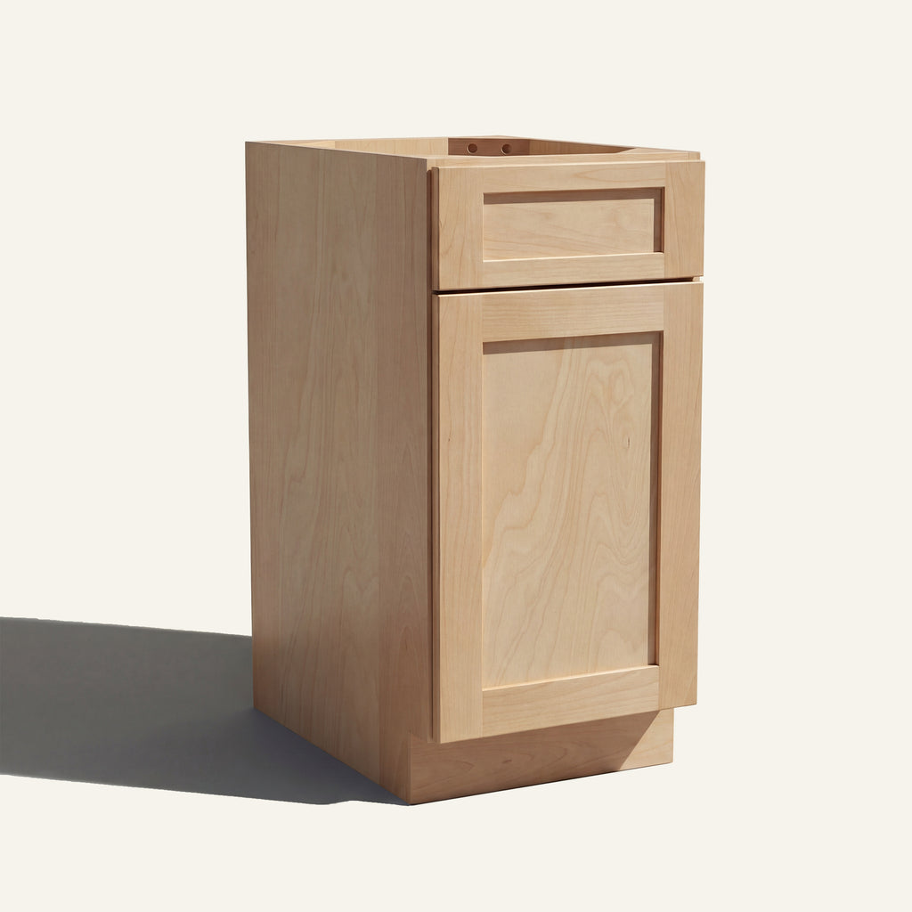 Angled view of a natural Seaport Shaker vanity base cabinet with 1 door and 1 drawer.
