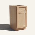 Angled view of a natural Seaport Shaker vanity base cabinet with 1 door and 1 drawer.