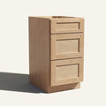 Angled view of a natural Seaport Shaker vanity base with 3 drawers stacked.