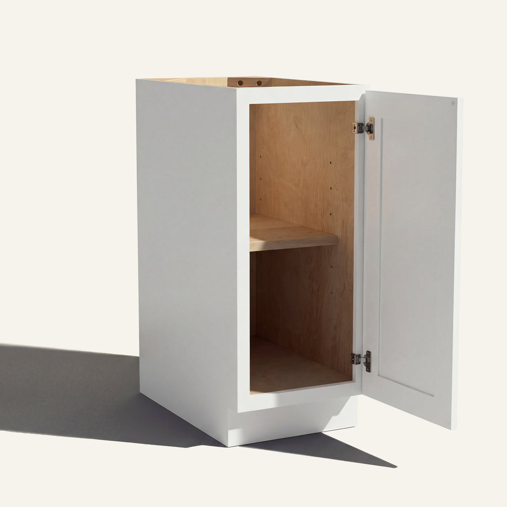 Angled view of a white Seaport Shaker base cabinet with 1 door open showing wood interior and shelf.
