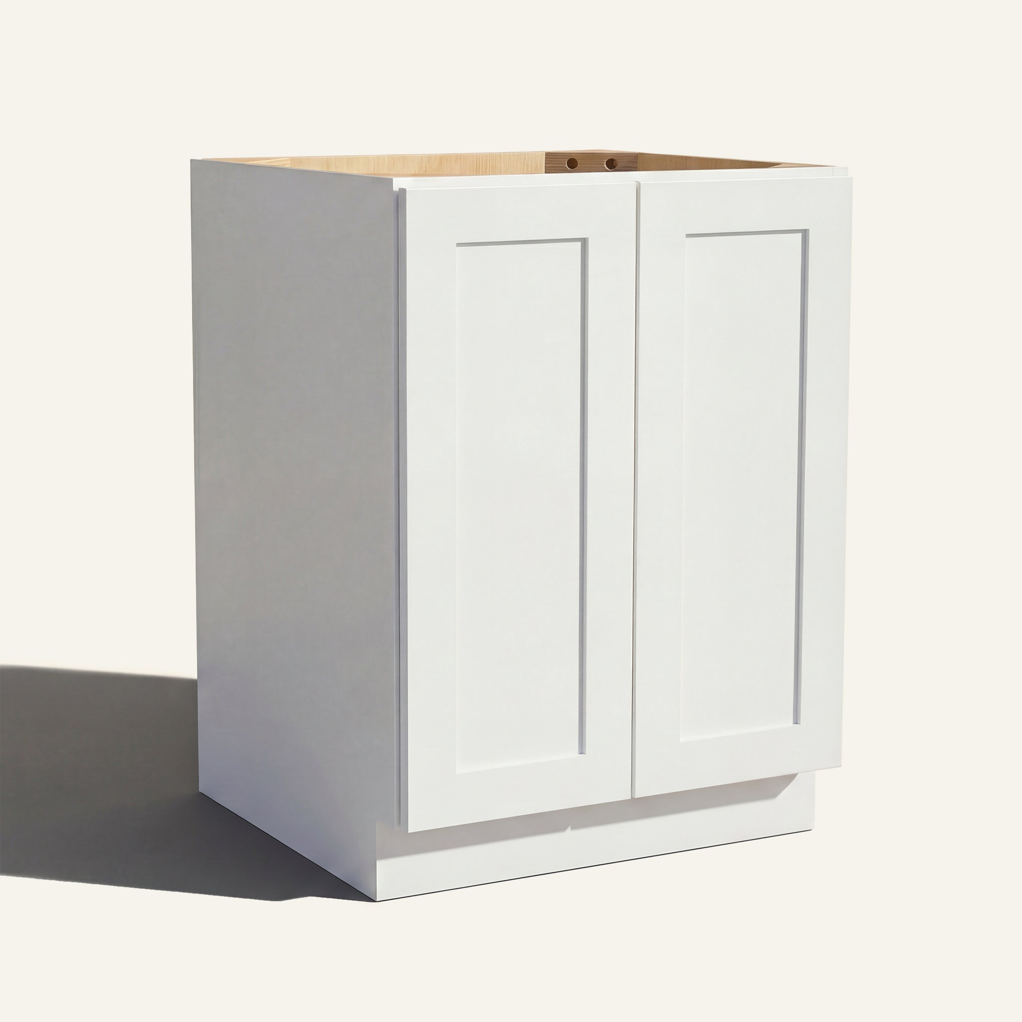Angled view of a white Seaport Shaker base cabinet with 2 full height doors.