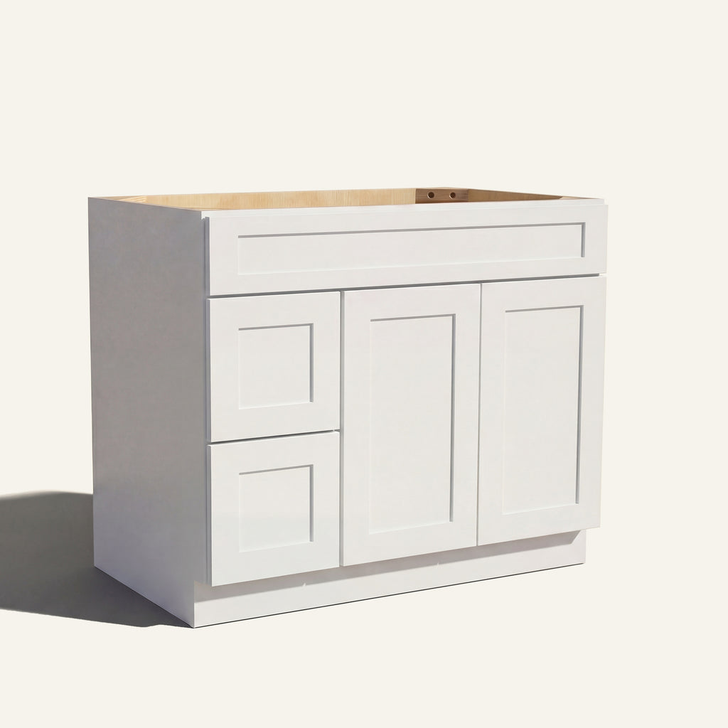 Angled view of a white Seaport shaker single sink vanity featuring two doors and a left-side drawer bank.