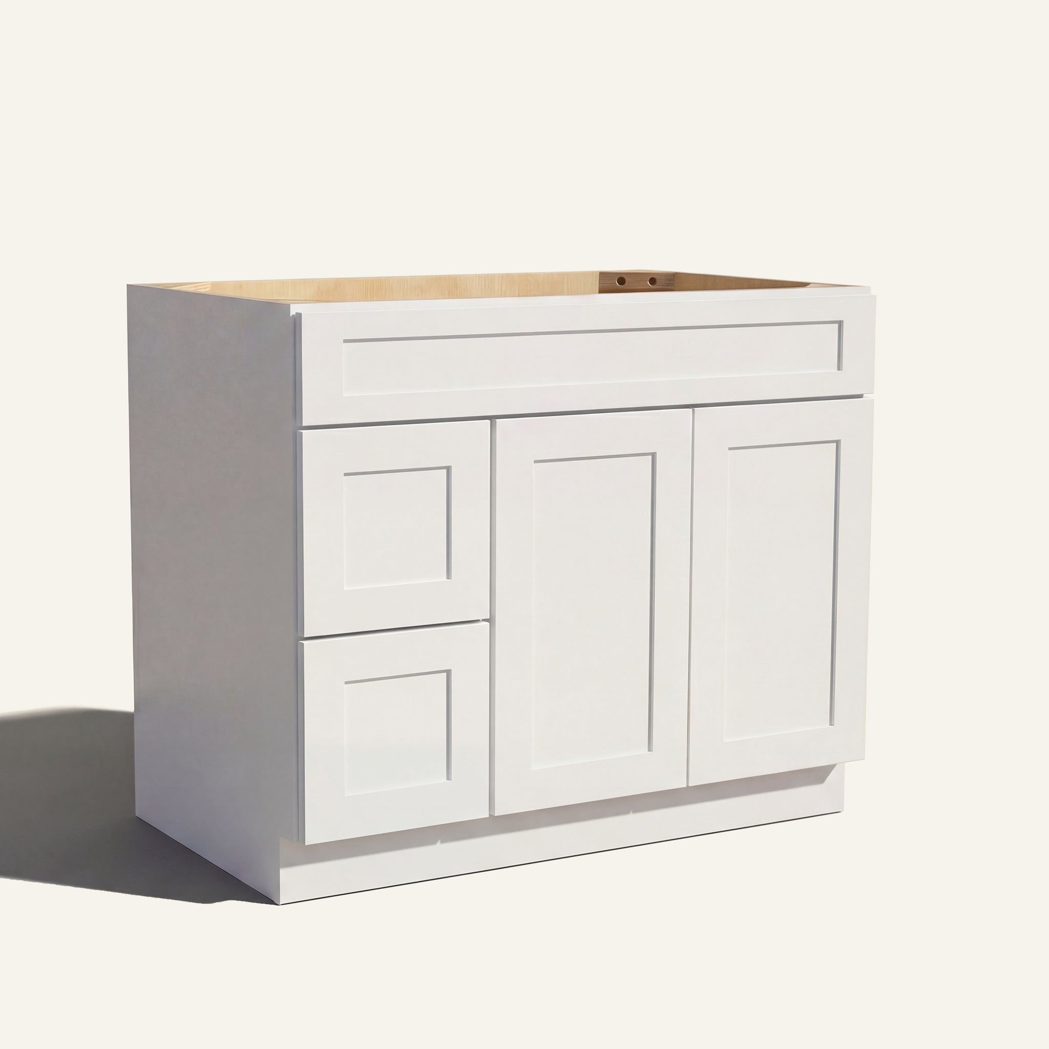 Angled view of a white Seaport shaker single sink vanity featuring two doors and a left-side drawer bank.