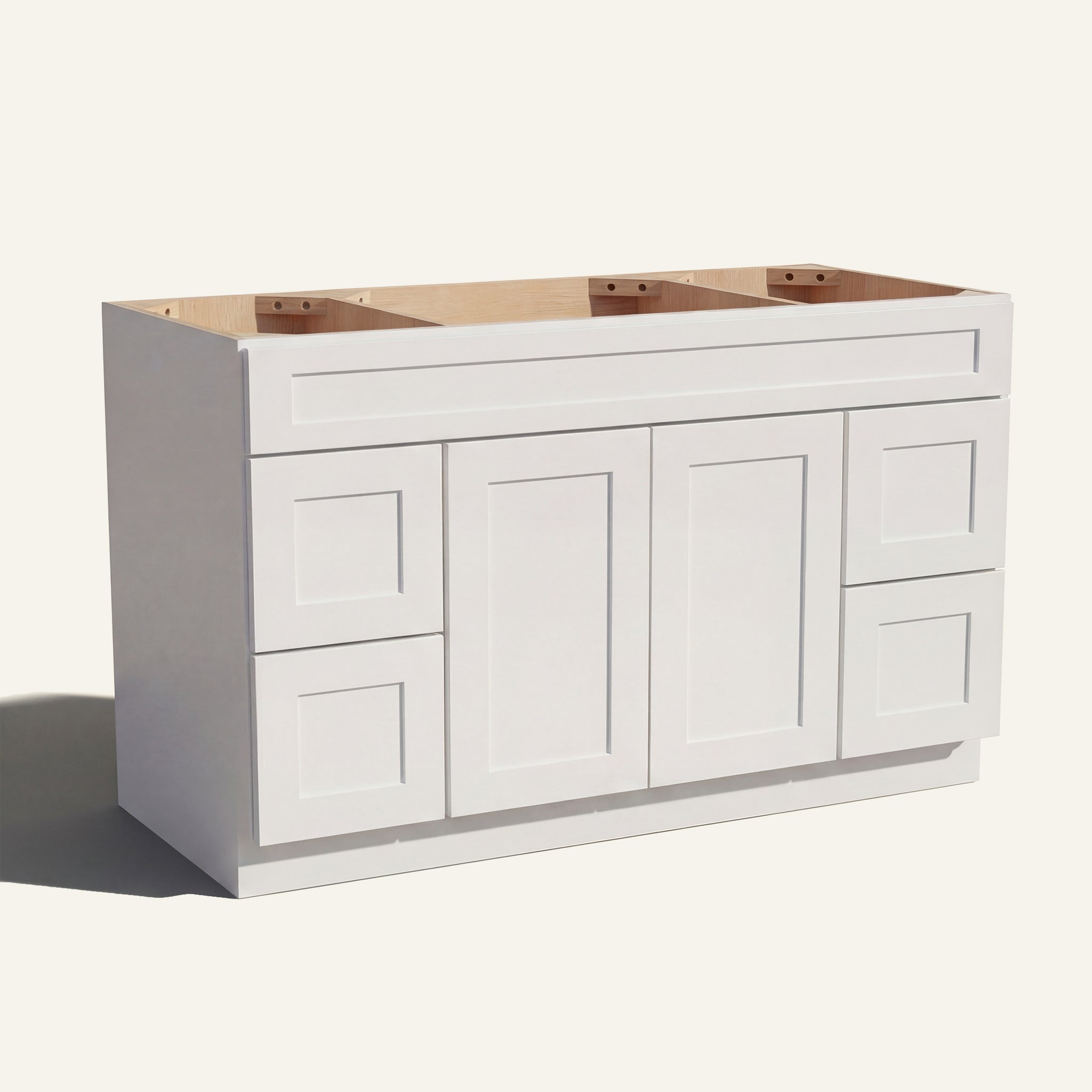 Angled view of a white Seaport Shaker wide single sink vanity base with 2 doors, 4 drawers, and 1 false drawer front.