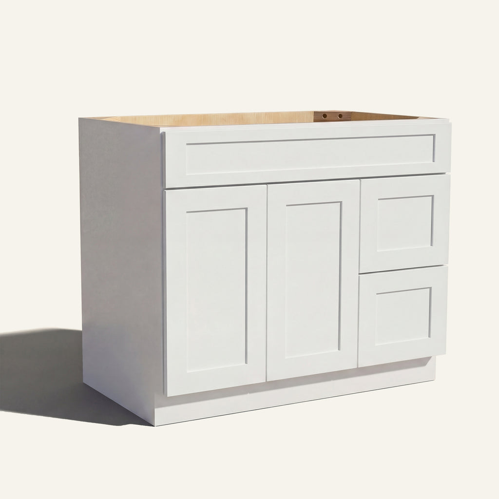 Angled view of white Seaport Shaker single sink vanity, 2 doors, 2 drawers right, and 1 false drawer front.