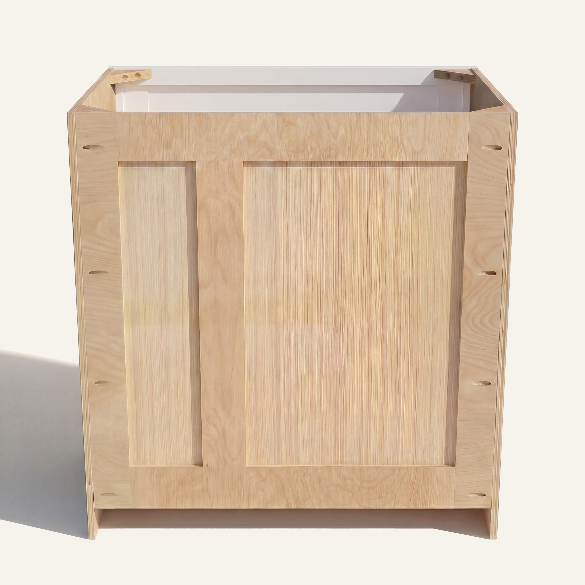 Rear view of a white Seaport vanity with offset plumbing supports, pocket screw holes, and builder grade plywood construction.