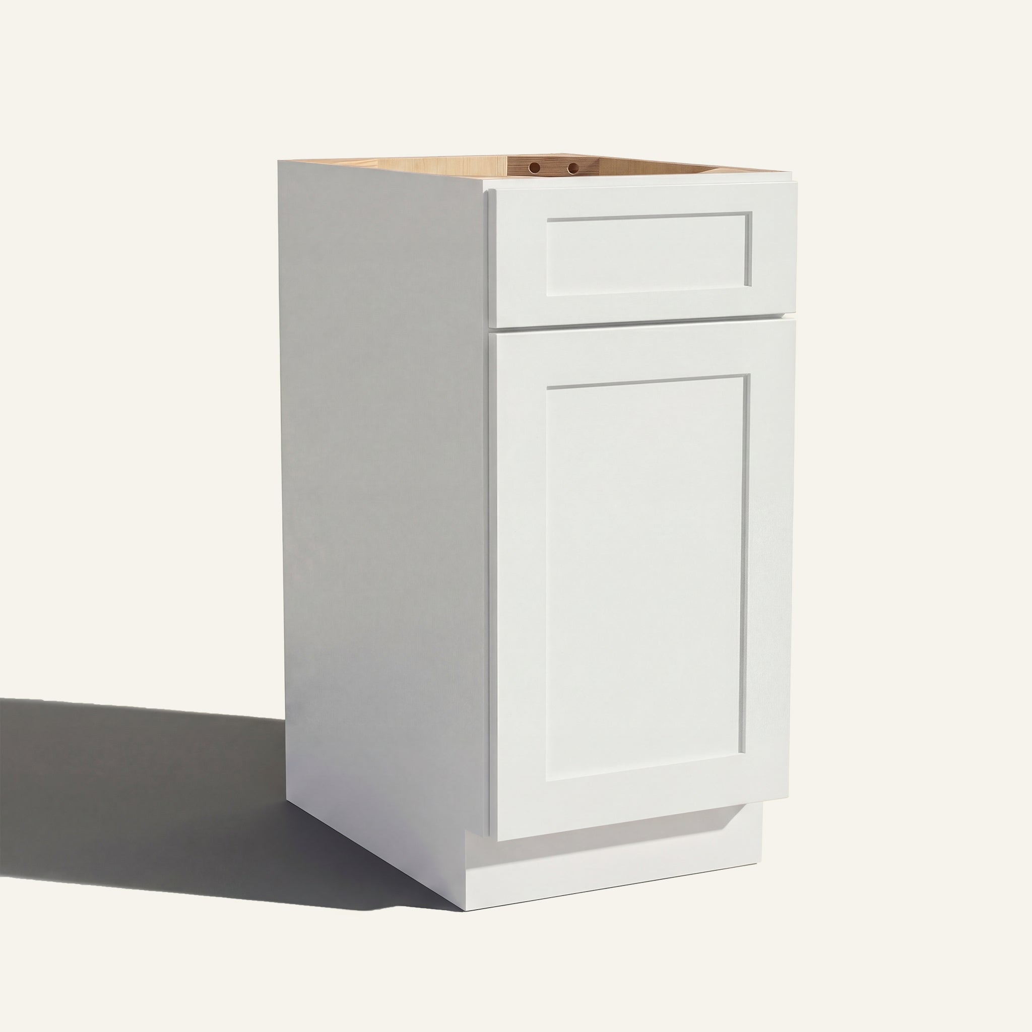 Angled view of a white Seaport Shaker vanity base cabinet with 1 door and 1 drawer.