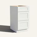 Angled view of a white Seaport Shaker vanity base with 3 drawers stacked.