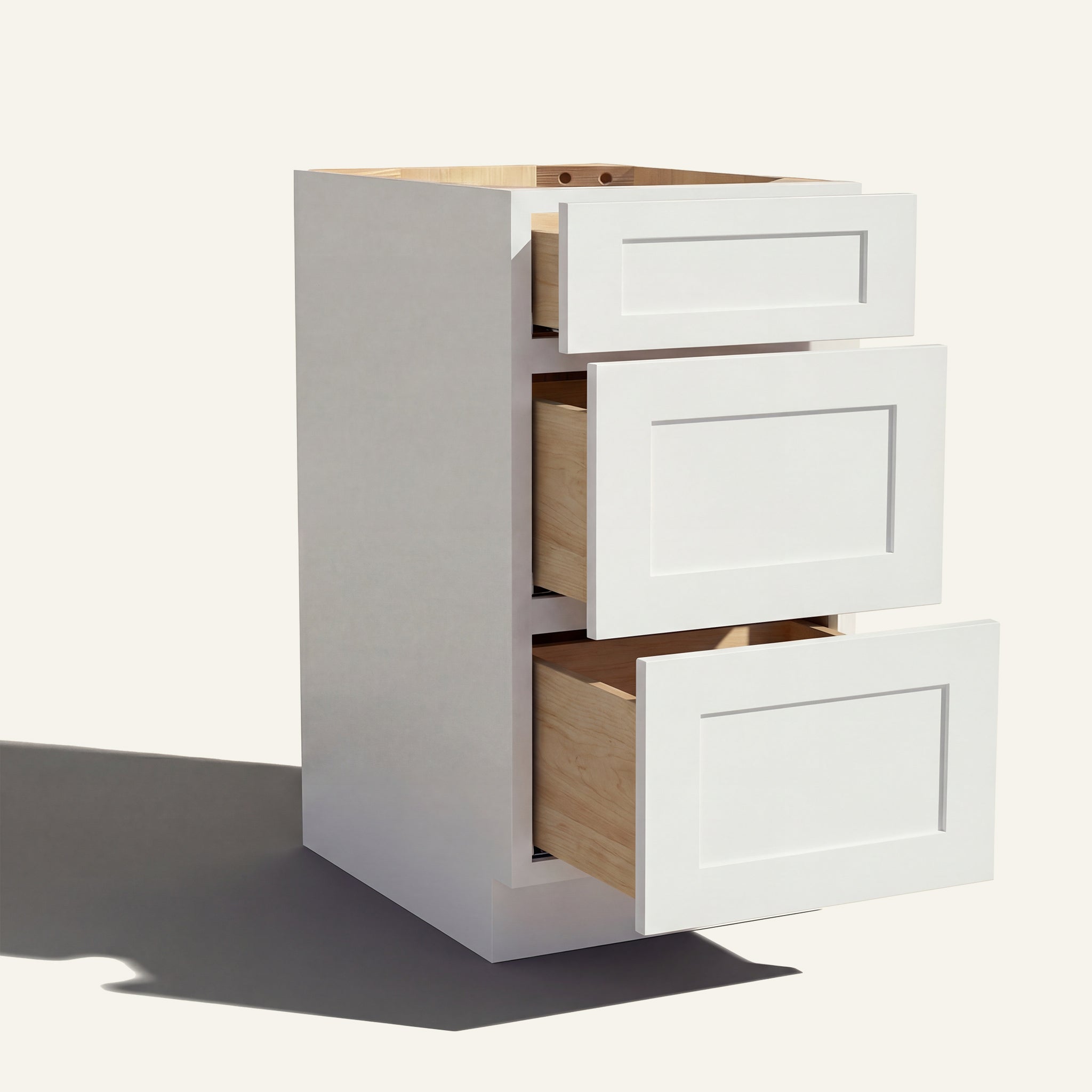 Angled view of a white Seaport Shaker 3-drawer vanity base cabinet with drawers open showing solid wood drawer boxes.